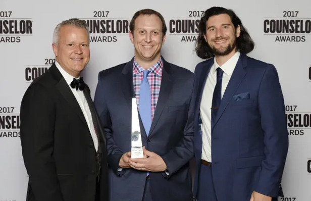 three men, middle holding award