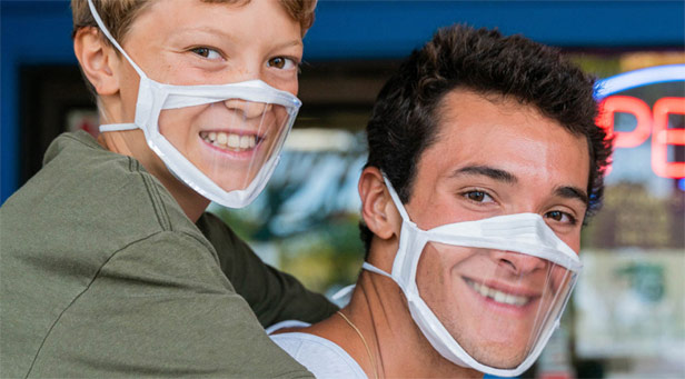 Boy and man wearing clear face masks