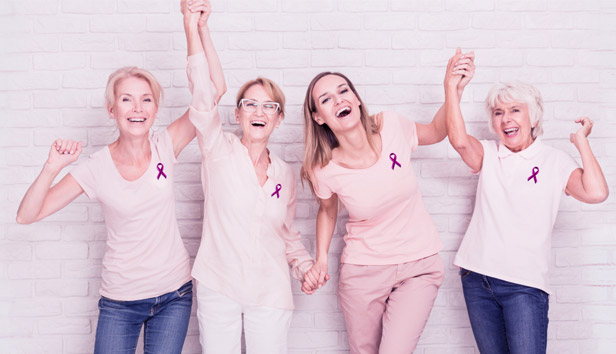 Women wearing pink holding hands