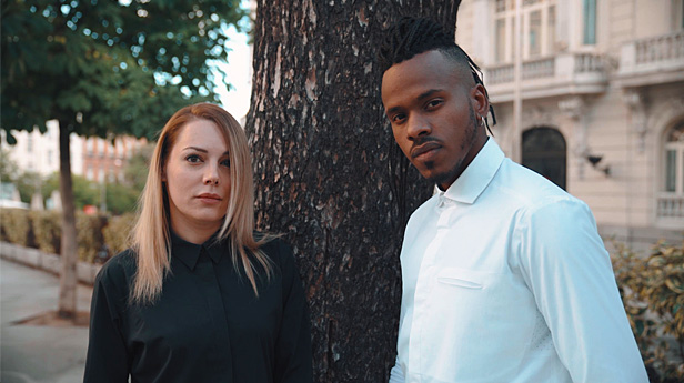 Man and woman standing next to tree