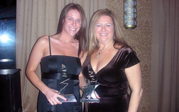 Two women (Tara Smith & Kelly Chiccit) holding awards