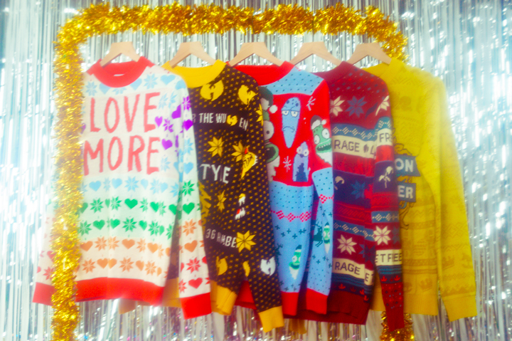 holiday sweaters against backdrop of tinsel and garland
