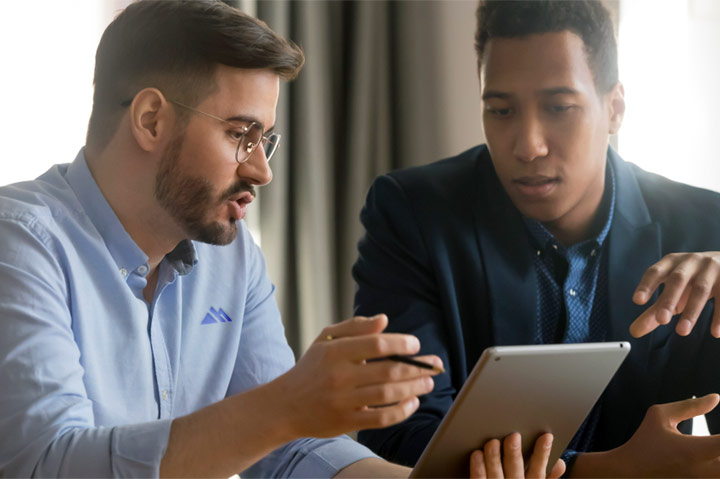 co-workers having discussion while looking at iPad