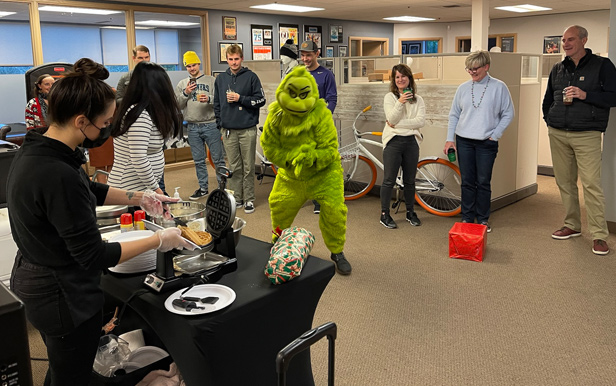 Image Source staff at holiday party, person dressed as Grinch