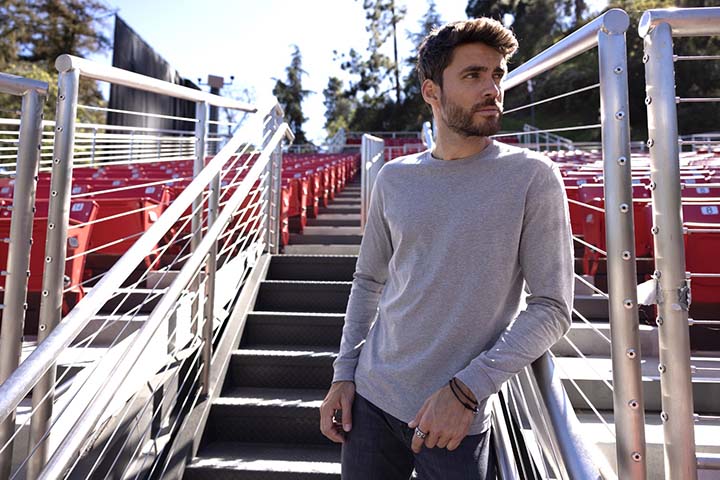 Young man standing next to seats at an outdoor concert venue