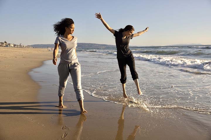 Young people on the beach splashing in the surf