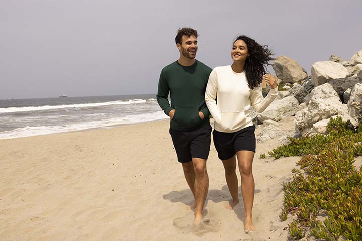 Young people walking on beach in Next Level Apparel clothing