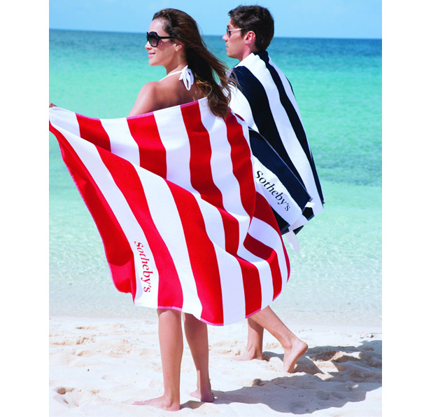 man and woman on beach wrapped in striped towels