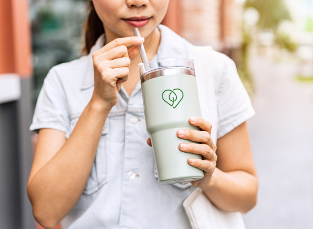 woman sipping from eco tumbler