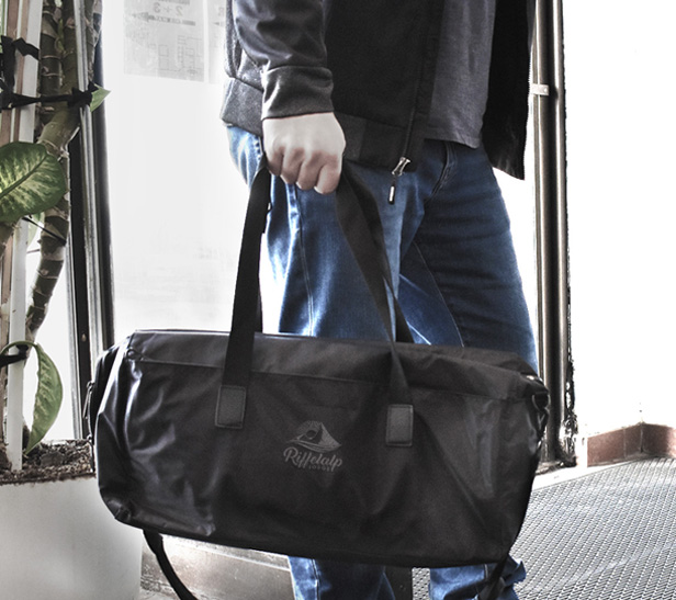 man holding black duffel bag