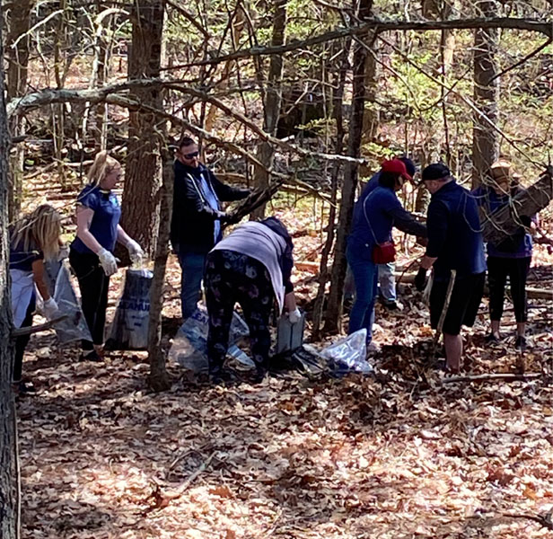 people cleaning up trash in woods