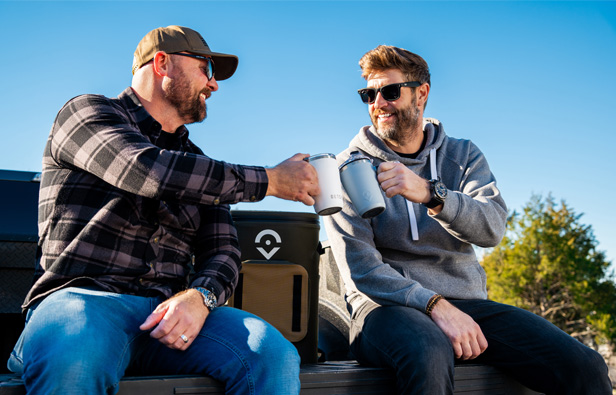 two guys toasting with reusable drinkware