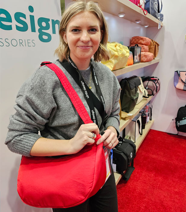 woman holding red bag in tradeshow booth