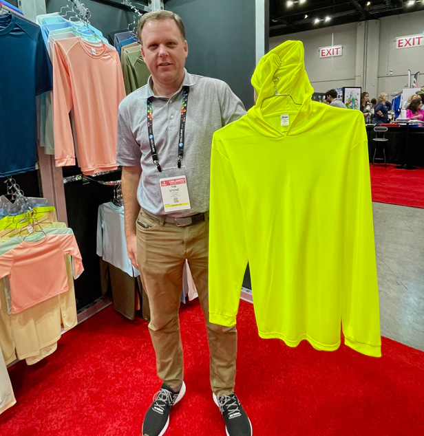 man holding up yellow shirt