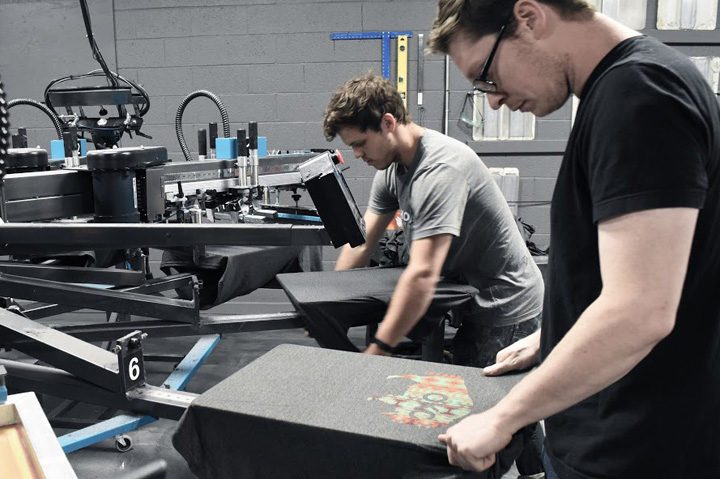 two men screen printing t-shirts