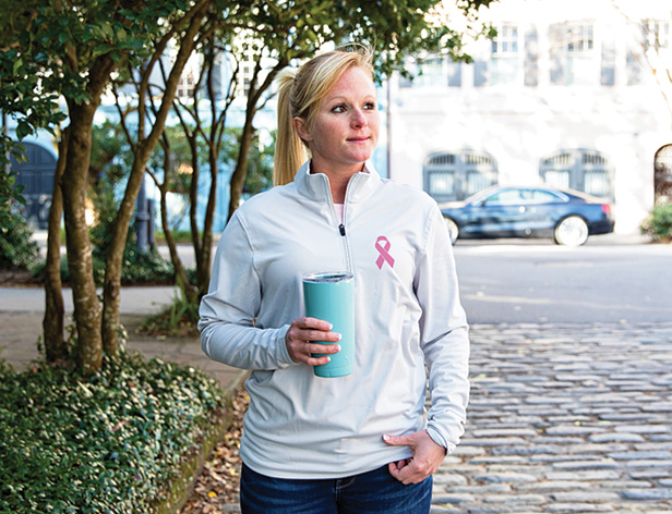 woman wearing quarter-zip with pink breast cancer ribbon logo