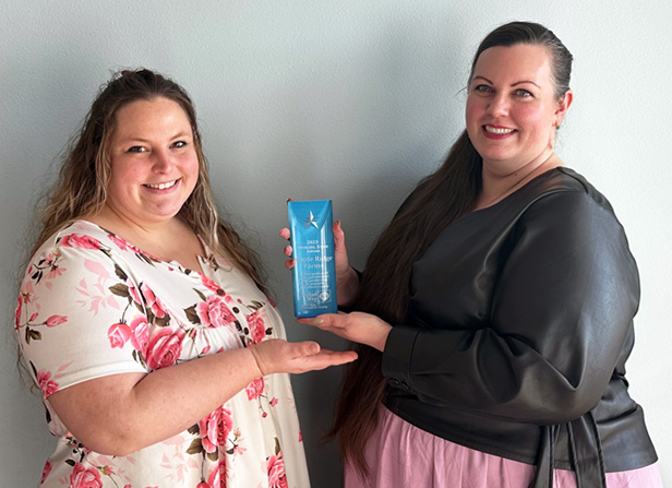 Two women holding an award