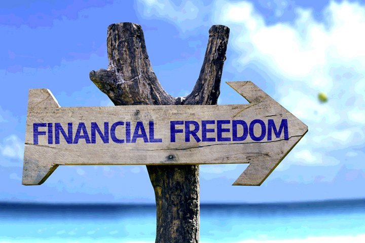Financial Freedom on wooden sign, ocean in background