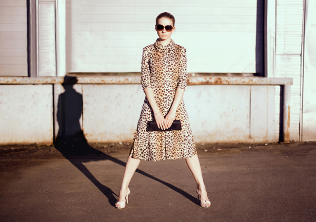 woman posing on street in a leopard print dress